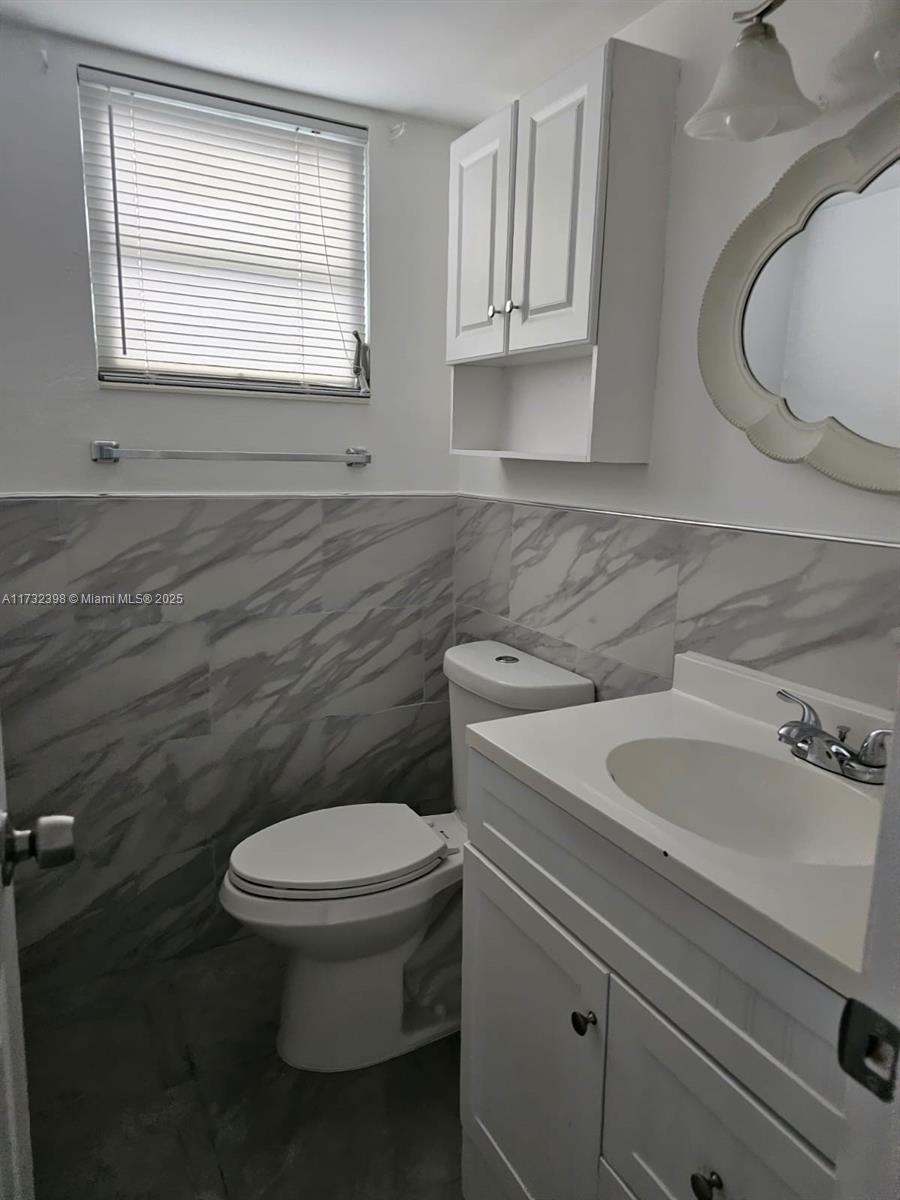 3777 Northwest 78th Avenue, Unit 3H Davie, FL 33024 - Photo 14 of 34 a bathroom with a sink a toilet and a mirror