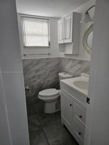 a bathroom with a sink a toilet and a window