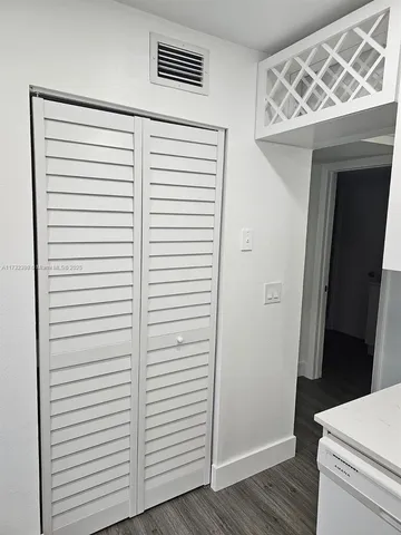 a view of a room that has a door and a white wooden floor