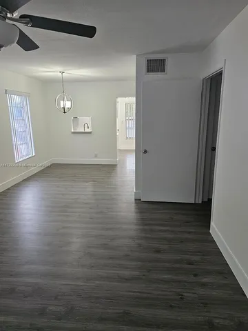 a view of a livingroom with an empty space wooden floor and window