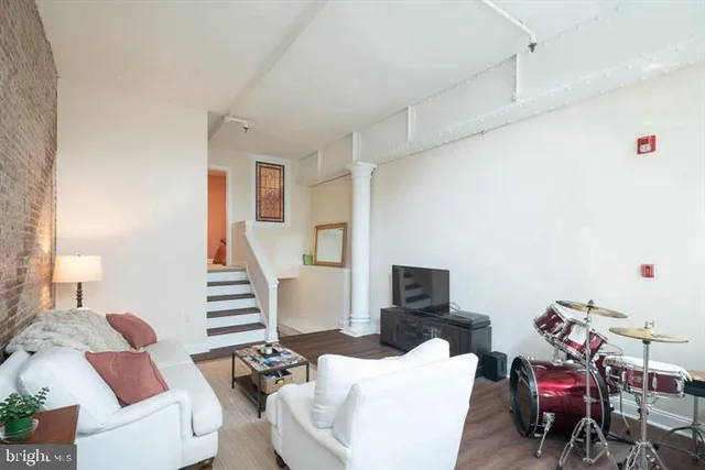 a living room with furniture and a wooden floor
