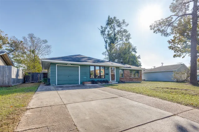 a front view of a house with a garden and trees