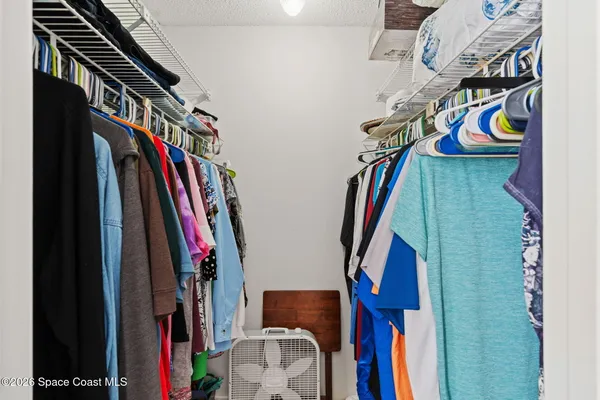 a view of walk in closet with clothes