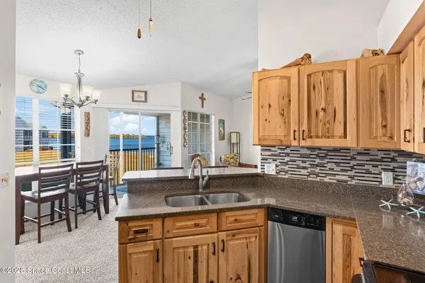 a kitchen with stainless steel appliances granite countertop a sink a stove and a wooden cabinets
