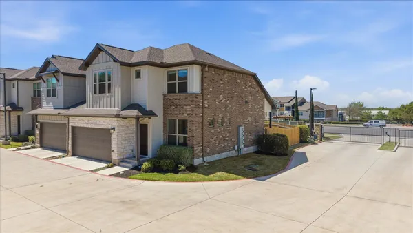 a view of a white house with a yard and plants
