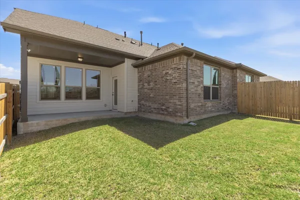 a view of a backyard with wooden fence