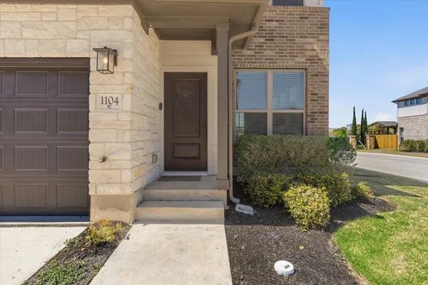 a view of a house with a small yard and wooden fence