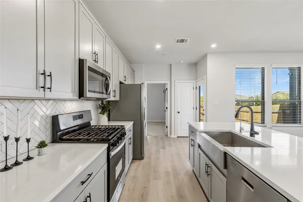 a kitchen with stainless steel appliances a refrigerator sink and cabinets