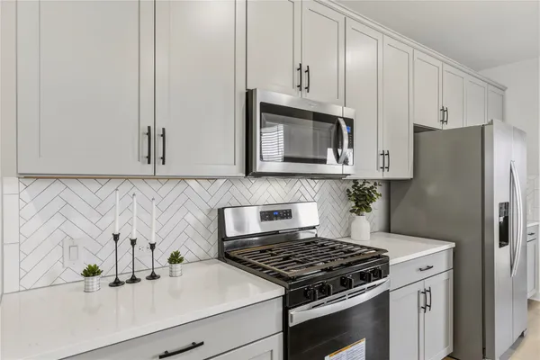 a kitchen with kitchen island granite countertop a sink a counter space appliances and cabinets
