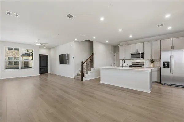a kitchen with granite countertop white cabinets and stainless steel appliances