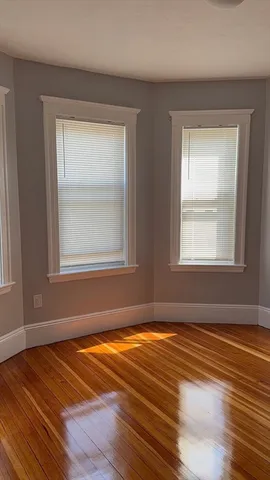 a view of a room with wooden floor and windows