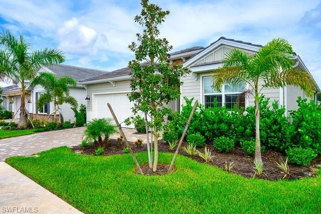 a front view of a house with a yard and potted plants