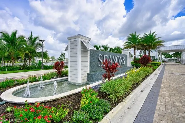 a view of a white house with a big yard and potted plants