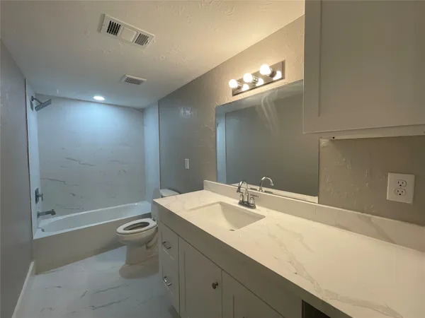 a bathroom with a sink a toilet a large mirror and shower