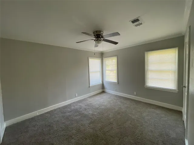 an empty room with a window and a ceiling fan