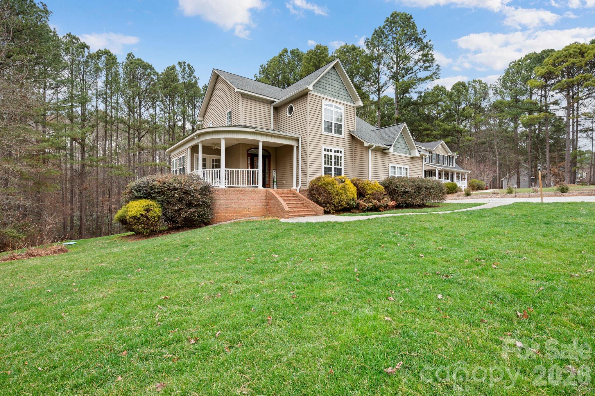 1606 High Ridge Drive Stanley, NC 28164 - Photo 1 of 43 a front view of a house with a garden and trees