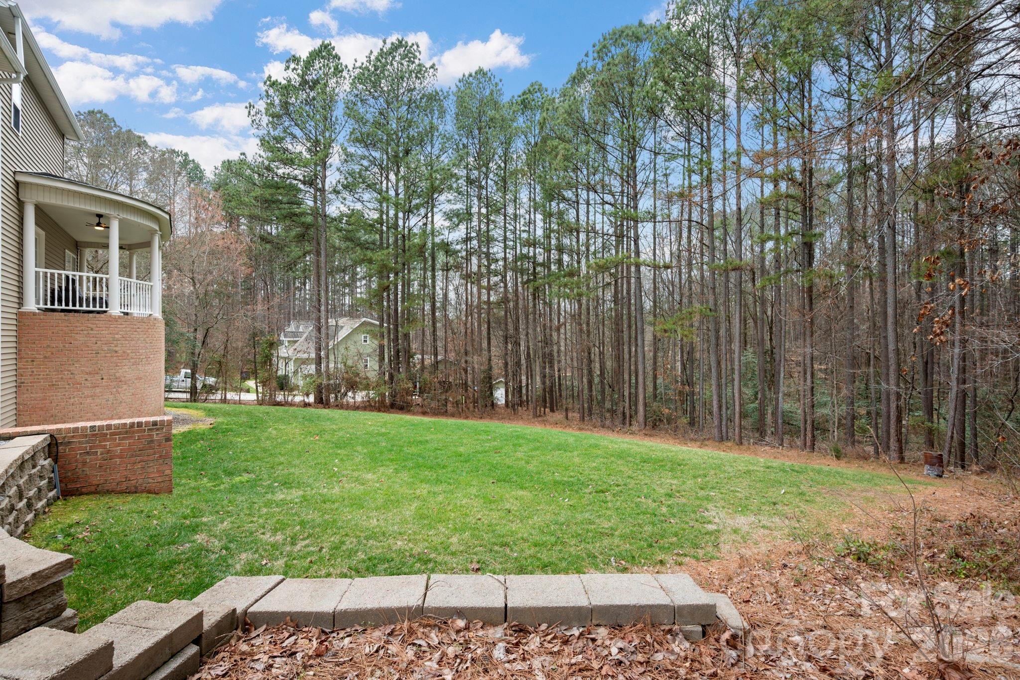 1606 High Ridge Drive Stanley, NC 28164 - Photo 37 of 43 a backyard of a house with plants and large trees