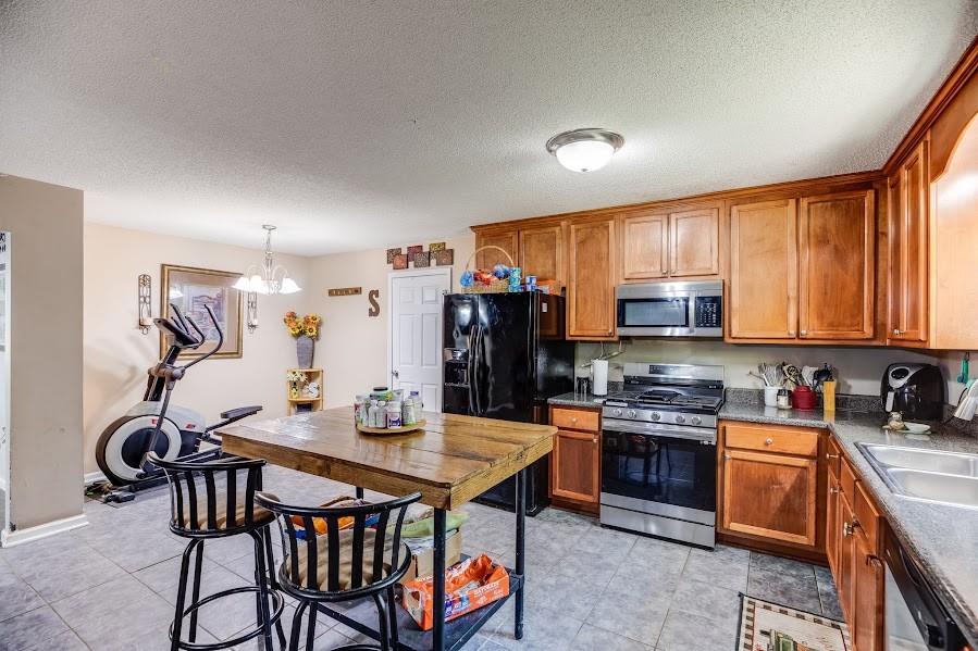 43 Mimosa Street Buchanan, GA 30113 - Photo 11 of 33 a kitchen with stainless steel appliances a stove a sink a refrigerator and chairs