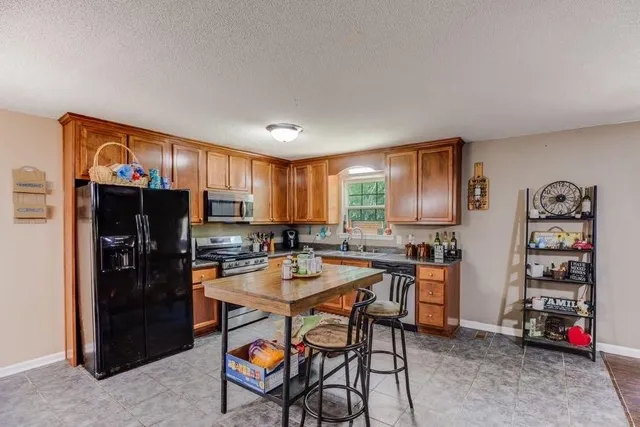 a kitchen with a refrigerator and a stove top oven