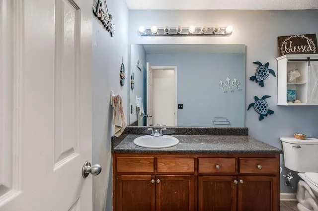 a bedroom with a baby bed a flat tv screen and a dresser