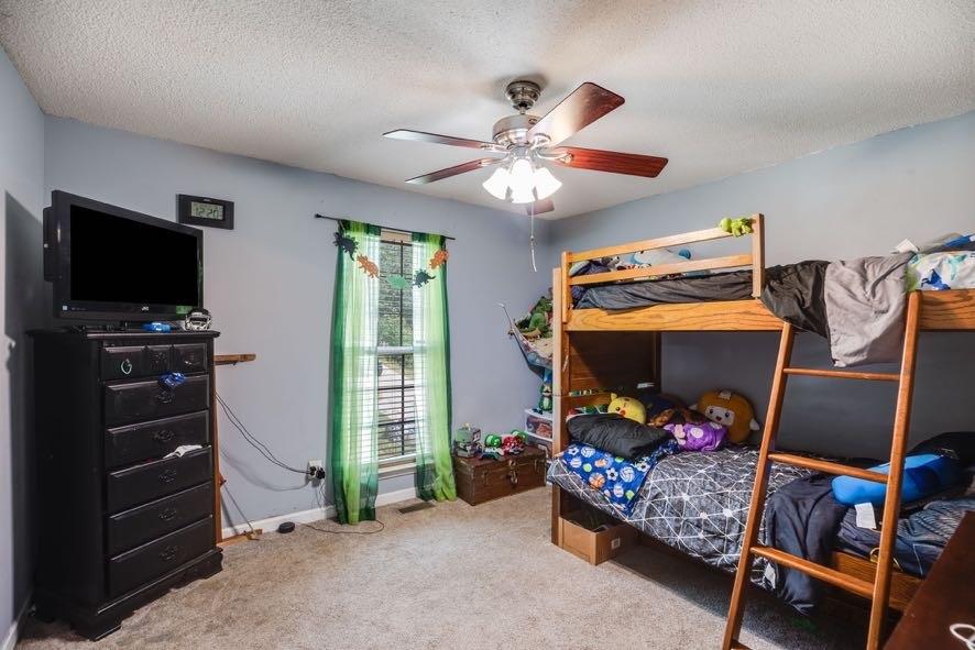 43 Mimosa Street Buchanan, GA 30113 - Photo 21 of 33 a bedroom with a baby bed a flat tv screen and a dresser