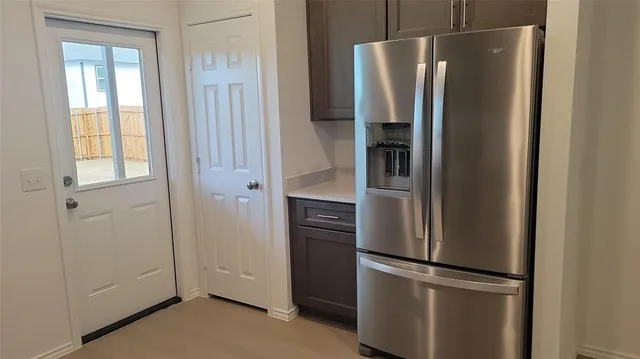 a metallic refrigerator freezer sitting in a kitchen