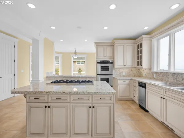 a kitchen with stainless steel appliances granite countertop a stove a sink and a refrigerator