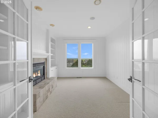 a view of an empty room with a fireplace and a window