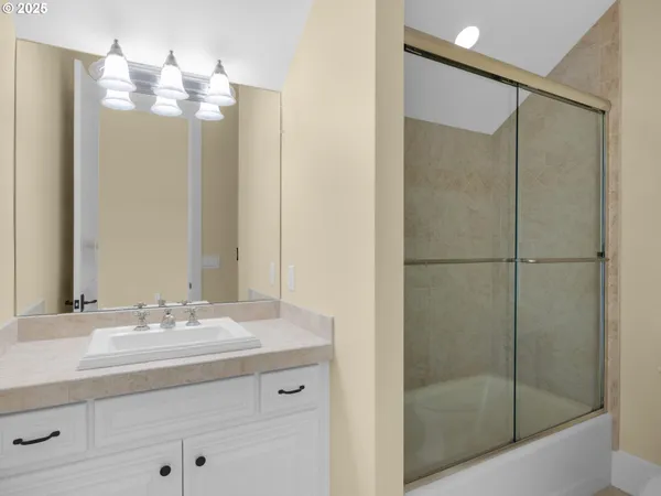 a bathroom with a shower sink and mirror