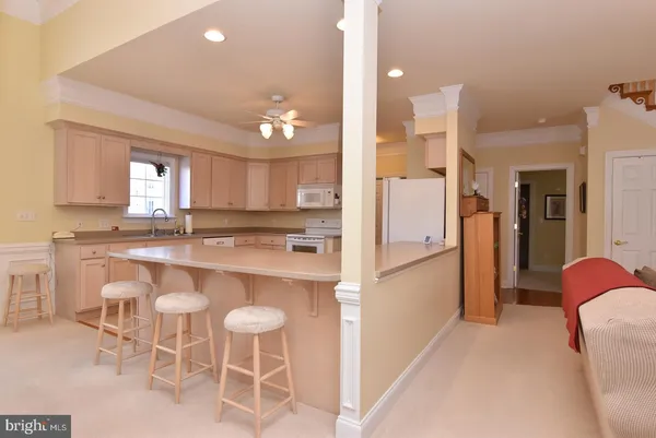 a kitchen with kitchen island granite countertop lots of white cabinets and stainless steel appliances