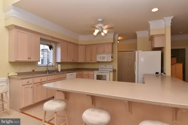 a kitchen with a refrigerator a sink cabinets and wooden floor