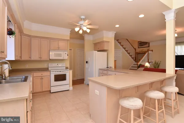 a kitchen with kitchen island a stove a table chairs sink and cabinets