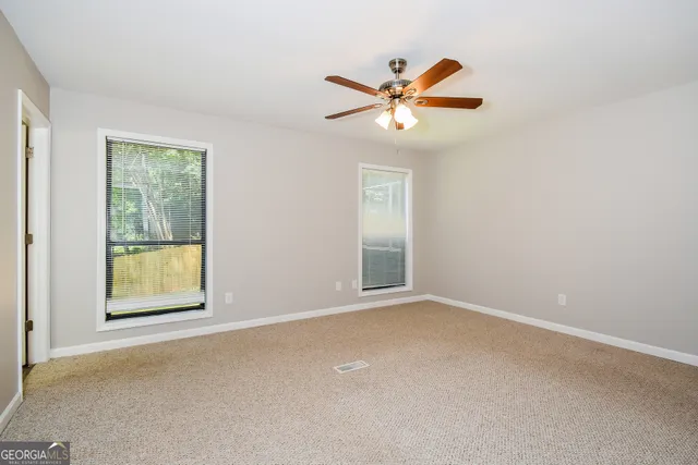 a view of empty room with ceiling fan
