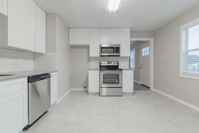 a kitchen with stainless steel appliances a stove microwave and refrigerator
