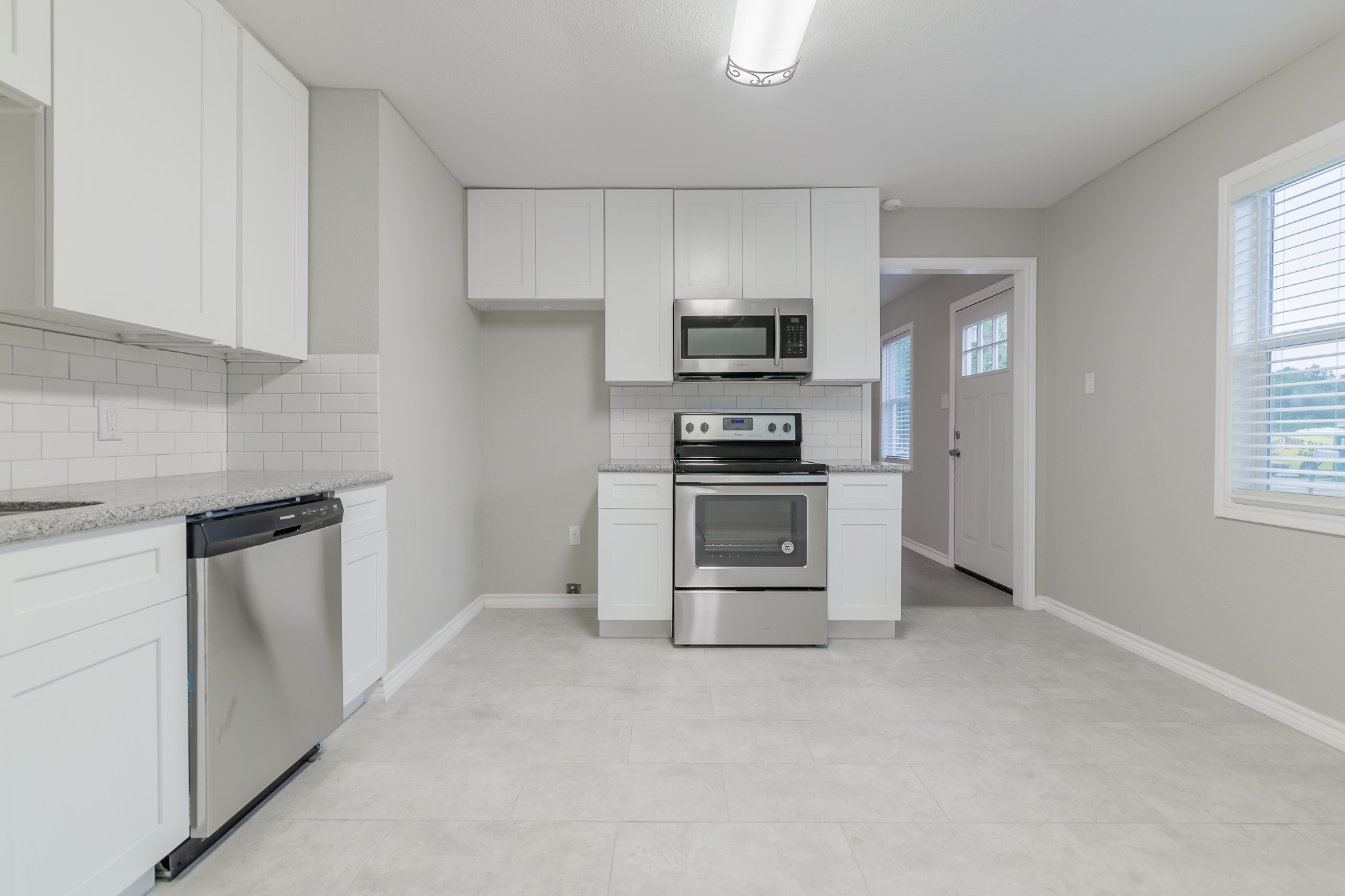 101 Will Street Willis, TX 77378 - Photo 6 of 25 a kitchen with stainless steel appliances a stove microwave and refrigerator