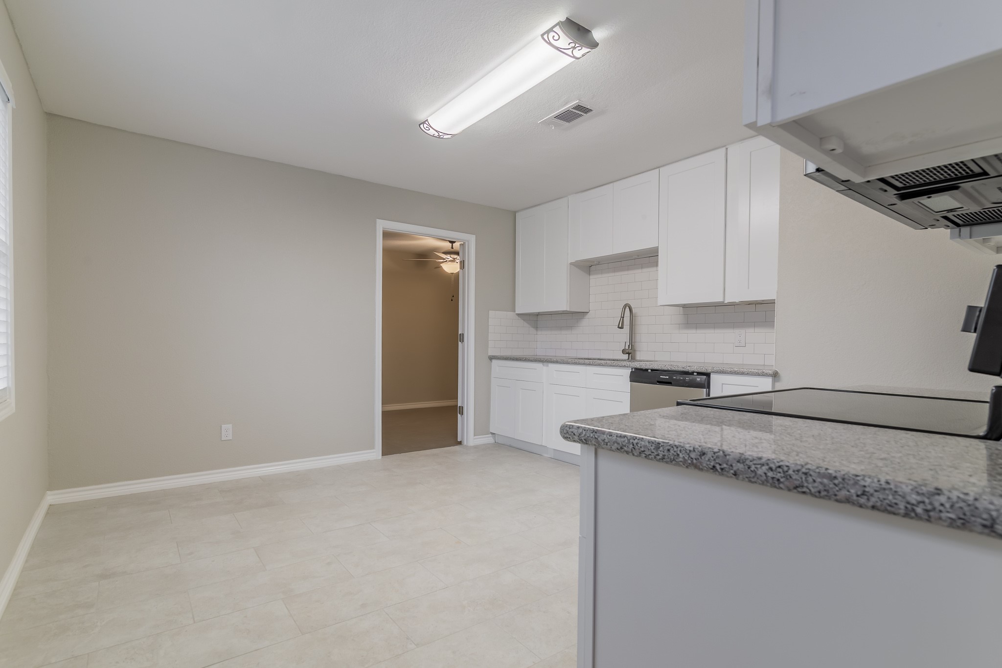 101 Will Street Willis, TX 77378 - Photo 10 of 25 a kitchen with granite countertop a sink stainless steel appliances and white cabinets
