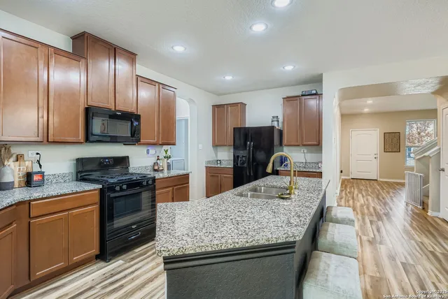 a kitchen with granite countertop stainless steel appliances and wooden cabinets
