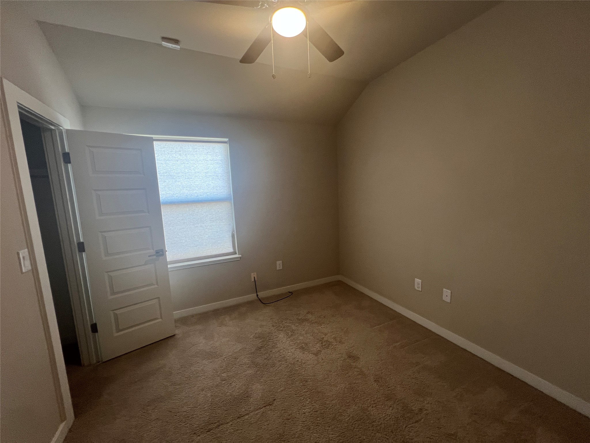 7009 Sienna Rouge Path Austin, TX 78744 - Photo 13 of 29 Empty room with lofted ceiling, light carpet, and ceiling fan