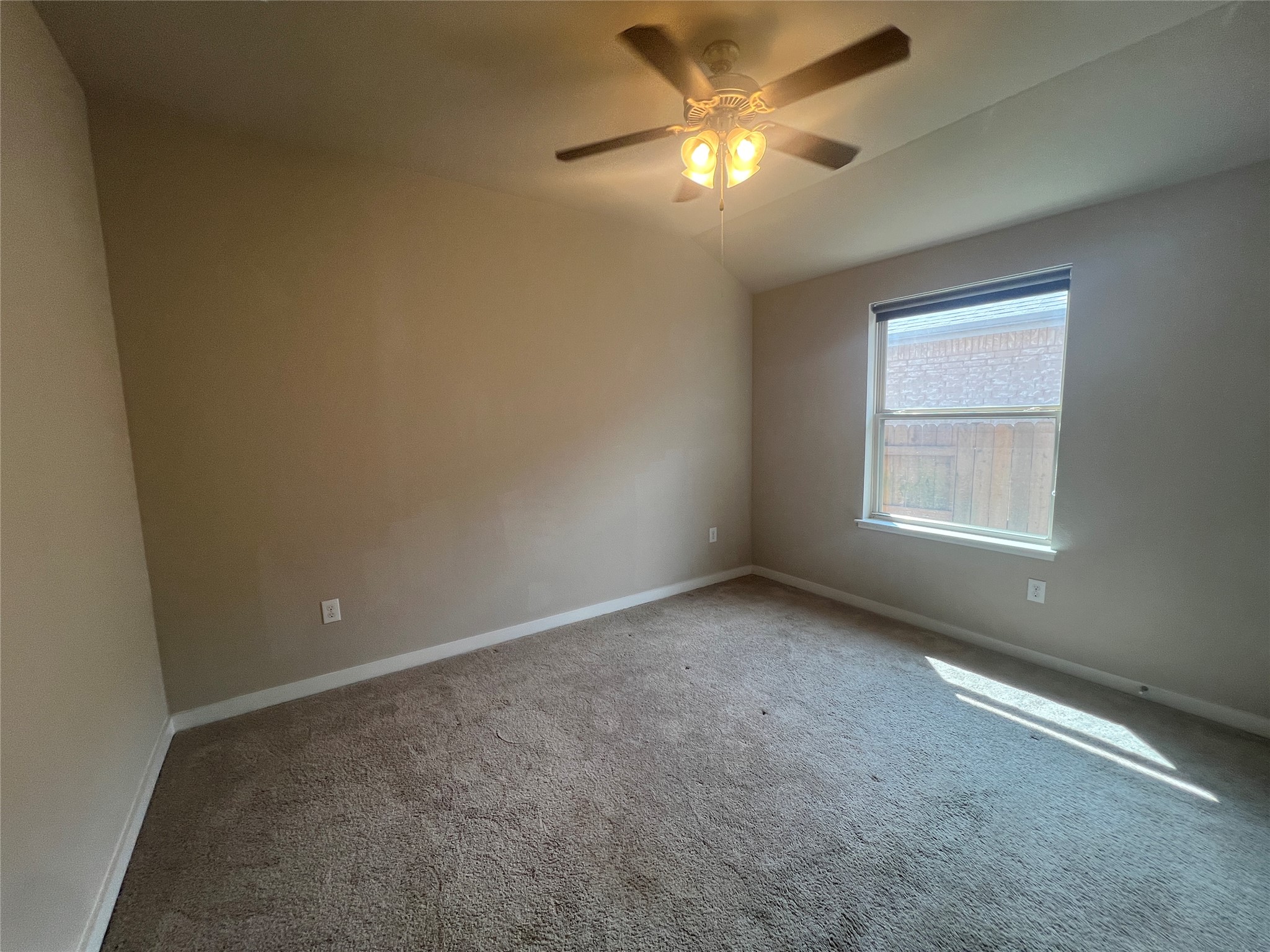 7009 Sienna Rouge Path Austin, TX 78744 - Photo 14 of 29 Carpeted empty room featuring vaulted ceiling and ceiling fan