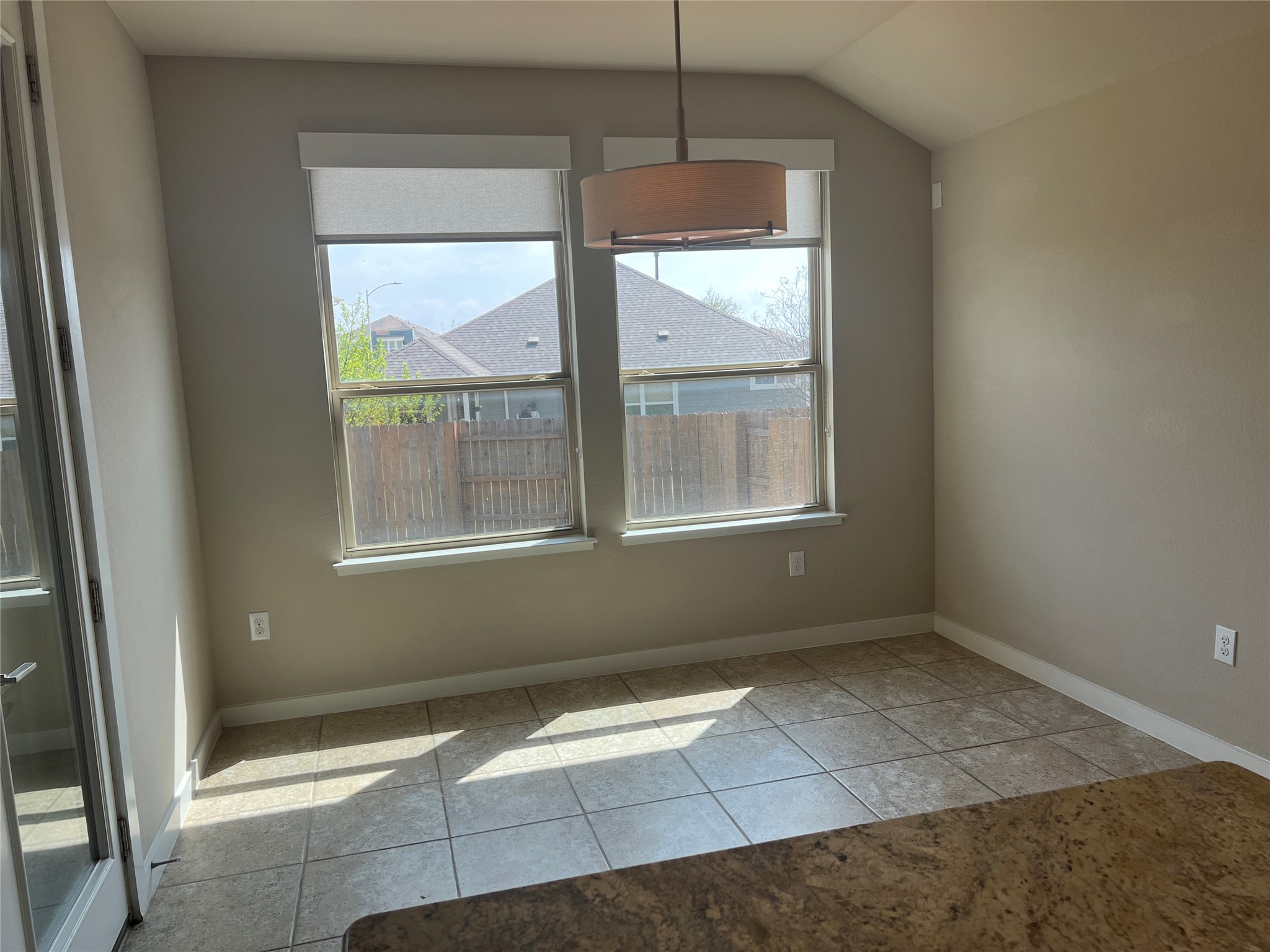 7009 Sienna Rouge Path Austin, TX 78744 - Photo 4 of 29 Unfurnished dining area with light tile patterned flooring and lofted ceiling
