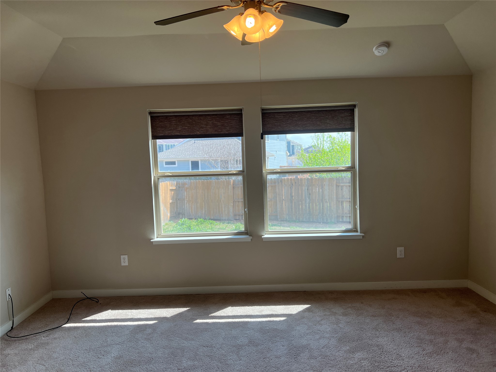 7009 Sienna Rouge Path Austin, TX 78744 - Photo 8 of 29 Spare room featuring a ceiling fan, light colored carpet, and lofted ceiling