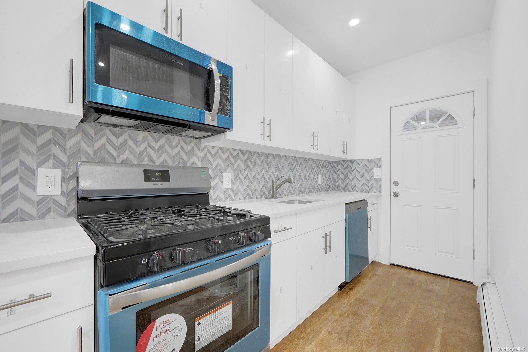 a kitchen with stainless steel appliances a stove a microwave a sink and cabinets