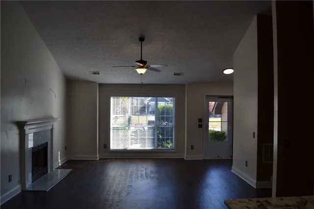 a view of an empty room with exposed radiator and fireplace