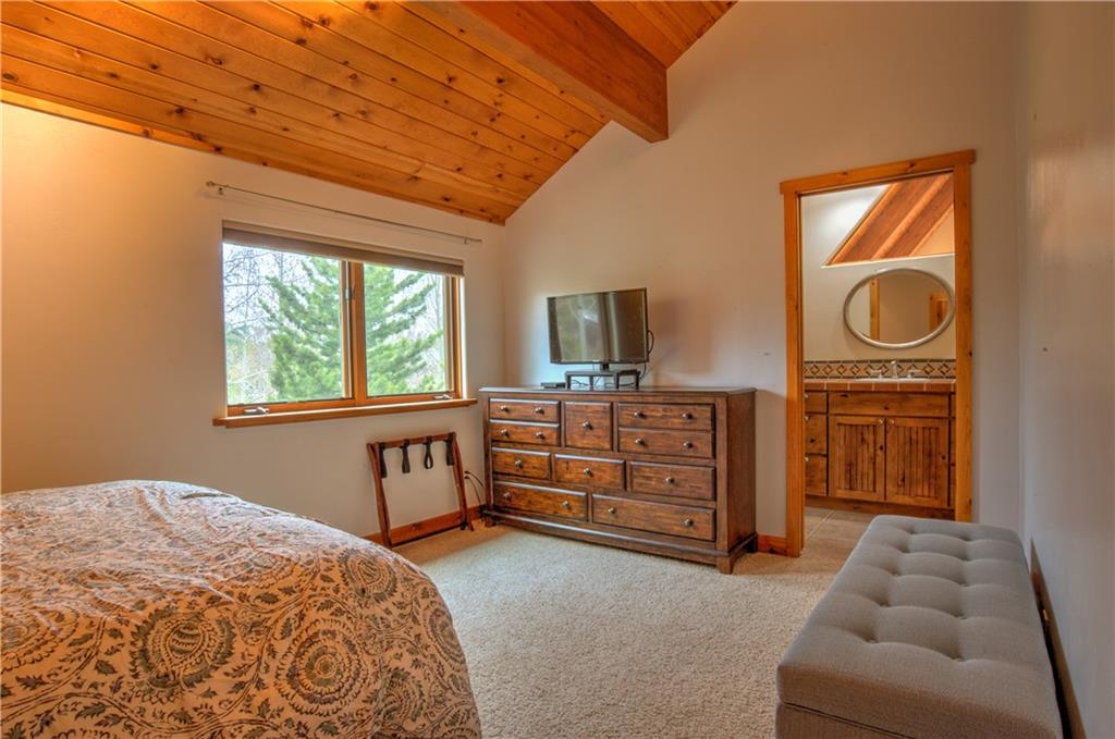 89 N Road Silverthorne, CO 80498 - Photo 24 of 35 a bedroom with a bed and furniture with a flat tv screen