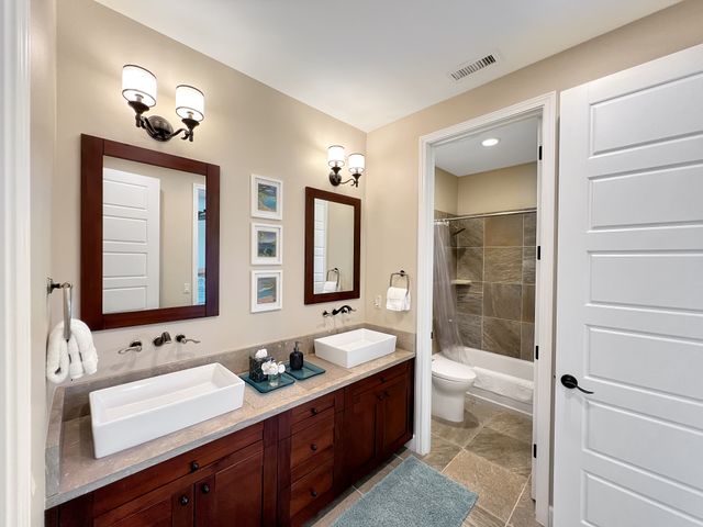 a spacious bathroom with a tub double sink and mirror