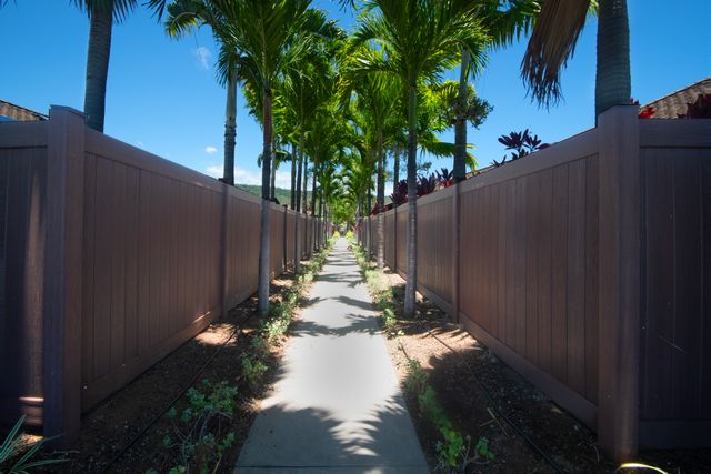 a backyard of a house with table and chairs plants and large tree