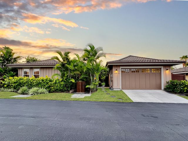 a front view of a house with a yard and potted plants