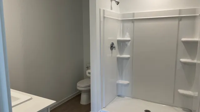 a bathroom with a toilet and a shower