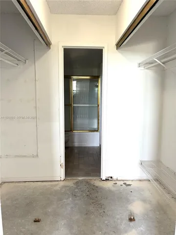 an empty room with windows and ceiling fan view