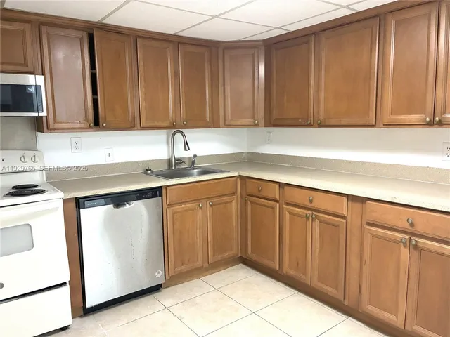 a kitchen with stainless steel appliances a stove a sink a microwave and cabinets